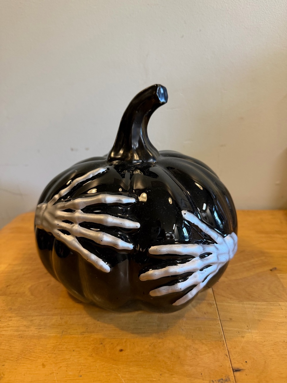 Black Ceramic Glossy Pumpkin with Skeleton Hands Wrapped Around Table Décor